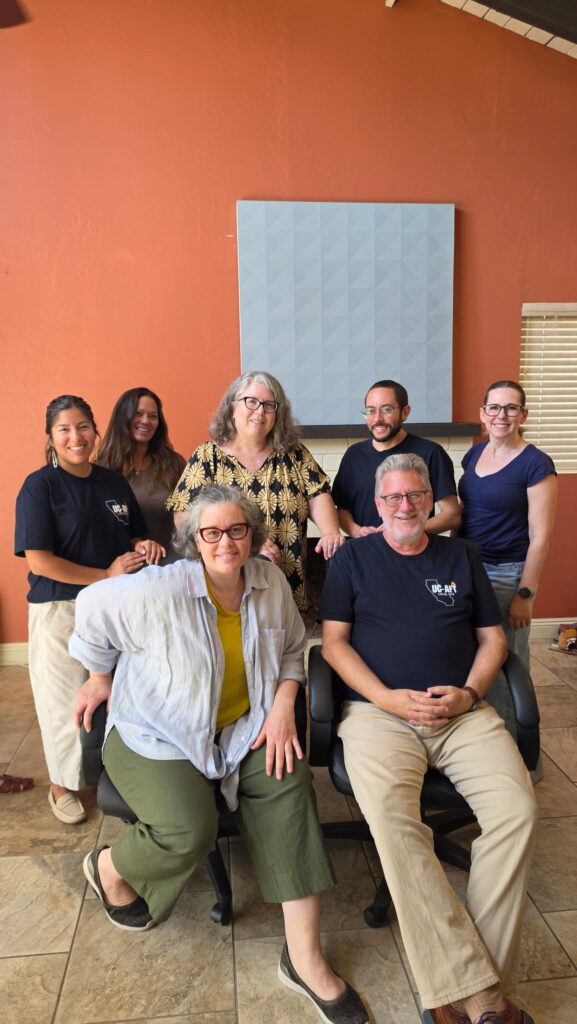 group portrait of teaching faculty, some wearing blue UC-AFT t-shirts