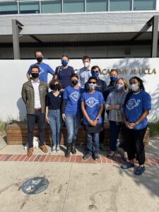 A group of teachers, several wearing blue UC-AFT t-shirts, outside Geffen Academy at UCLA. The teachers are wearing masks to protect one another during the COVID-19 pandemic.