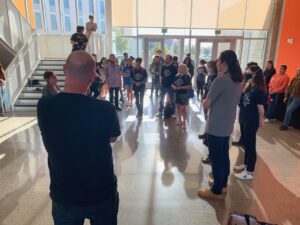 Lecturers and their students stand in a lobby listening to an administrator speak during an action at UC Merced in 2022.