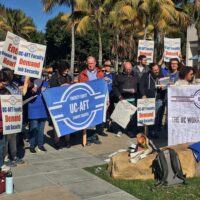 Members of the UCSB chapter and their students and supporters at a rally in 2021. Some hold pickets reading "End Unpaid Work Now!" and "UC-AFT Faculty Demand Job Security!". Some hold banners, one on the right reads "The UC Works Because We Do" with hundreds of member signatures. The one in the center reads "Faculty Equity- Student Success."