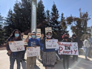 Members of the UCSB chapter wearing masks and holding handmade signs that read "Job Security now!!" "No Benefits" "Can't Pay My Student Loan" and "Professional in Poverty."