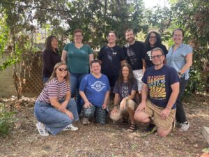 A group portrait of ten people, some in blue union teachers, in a backyard.