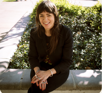 Dark haired woman wearing black sits for a portrait