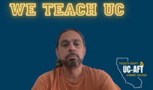 bearded man in an orange shirt seated in front of a navy blue background with banner "We Teach UC" and UC-AFT logo